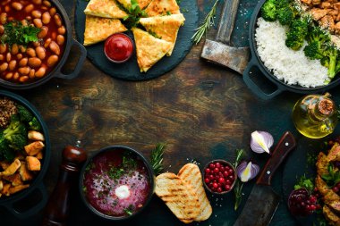 Yiyecekler. Tabakları masaya koyun. Ahşap bir arka planda. Üst Manzara. Boşluğu kopyala.