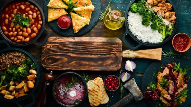 Yiyecekler. Tabakları masaya koyun. Ahşap bir arka planda. Üst Manzara. Boşluğu kopyala.