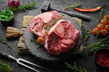 Taze et. Biberiye ve baharatlı Ossobuko bifteği. Siyah taştan bir arka planda. Üst görünüm.