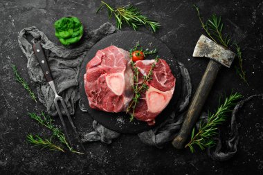 Taze et. Biberiye ve baharatlı Ossobuko bifteği. Siyah taştan bir arka planda. Üst görünüm.