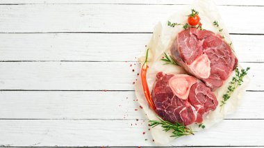 - Et. Biberiye ve baharatlı Osso buco dana biftek. Beyaz ahşap bir arka planda. Üst görünüm.