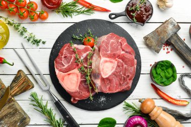 - Et. Biberiye ve baharatlı Osso buco dana biftek. Beyaz ahşap bir arka planda. Üst görünüm.