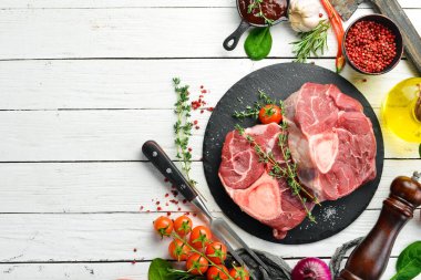 - Et. Biberiye ve baharatlı Osso buco dana biftek. Beyaz ahşap bir arka planda. Üst görünüm.