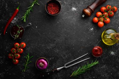 Siyah taş pişirme arka planı. Baharat ve sebze. Üst Manzara. Metnin için boş yer.