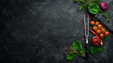 Siyah taş pişirme arka planı. Baharat ve sebze. Üst Manzara. Metnin için boş yer.