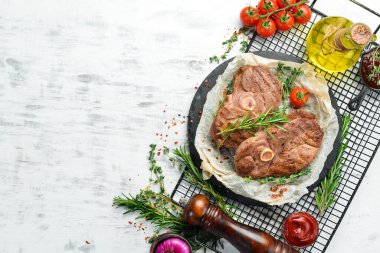 Barbekü. Beyaz ahşap arka planda baharatlı ve sebzeli kuzu biftek. Düz yatıyordu. Üst görünüm.