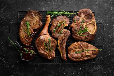 Barbekü. Kızarmış et ve biftek seti. Üst Manzara. Siyah taş kesme masasının üstünde düz bir görünüm vardı..