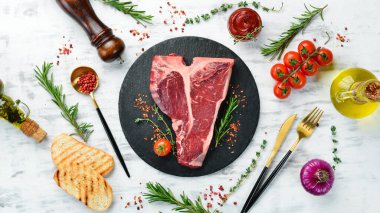 Beyaz ahşap arka planda baharatlı ve otlu çiğ biftek. Düz yatıyordu. Üst görünüm.