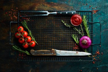 Baharatlar, otlar ve mutfak aletleriyle dolu siyah taş mutfak arka planı. Metin için boş alan. Üst Manzara. Kırsal biçim.