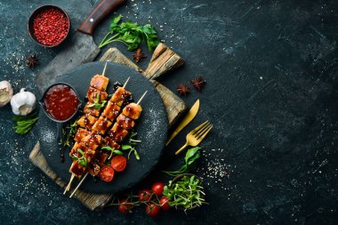 Siyah taş tabakta teriyaki soslu tavuk şişleri. Kırsal tarzda. Barbekü menüsü.
