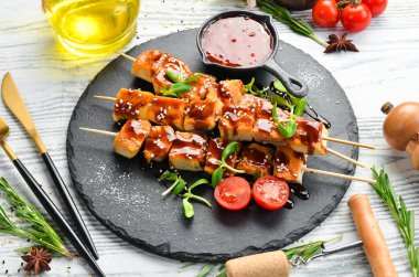 Siyah taş tabakta teriyaki soslu tavuk şişleri. Kırsal tarzda. Barbekü menüsü.