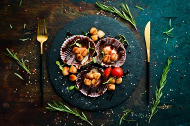 Kabuklu deniz tarağı ve siyah taş bir tabakta sebze. Lüks restoran yemekleri. Deniz ürünleri. Kırsal tarzda. Düz Yat.