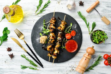 Siyah taştan bir tabakta sebzeli Rapana şişleri. Restoran yemeği. Deniz ürünleri. Kırsal tarzda. Düz Yat.