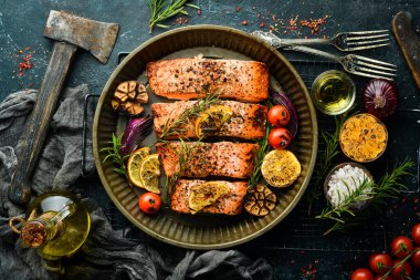 Metal bir tepside sebze ve biberiyeyle pişirilmiş somon balığı. Yemek tarifi. Deniz ürünleri. Metin için boş alan.