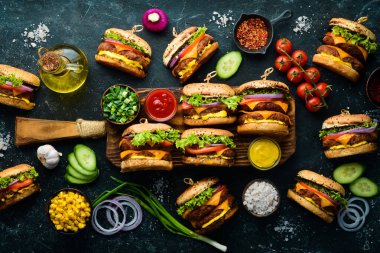 Taze sebzeli, etli ve peynirli ev yapımı hamburger. Üst Manzara. Siyah taştan bir arka planda.