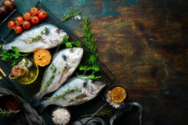 Çiğ balık, tarif. Baharatlı, limonlu ve kekikli Dorado balığı. Üst Manzara. Bedava fotokopi. Siyah taştan bir arka planda.