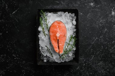 Buzlu çiğ somon bifteği. Karanlık bir arka planda. Üst görünüm.