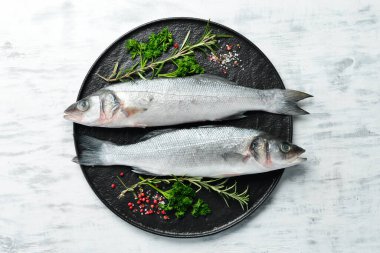 Baharatlı çiğ levrek balığı. Beyaz ahşap bir arka planda. Üst görünüm.