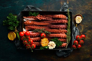 Metal bir kabın içinde baharat ve otlarla haşlanmış ahtapot dokunaçları. Üst Manzara. Düz yatıyordu.