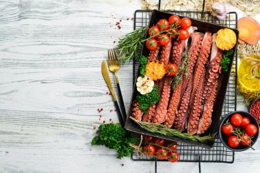 Metal bir kabın içinde baharat ve otlarla haşlanmış ahtapot dokunaçları. Üst Manzara. Düz yatıyordu.