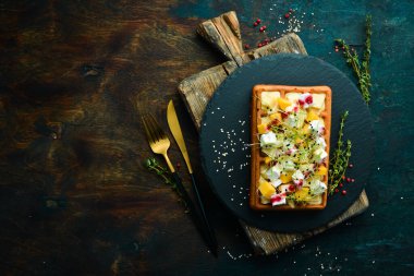 Kahvaltıda. Krem peynirli Belçika waffleları, peynir ve parmesan peyniri. Siyah taştan bir tabakta.