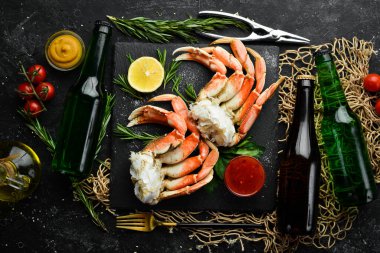 Siyah arka planda bira ve yengeç pençeleri. Kırsal tarzda. Deniz ürünleri lezzetleri..