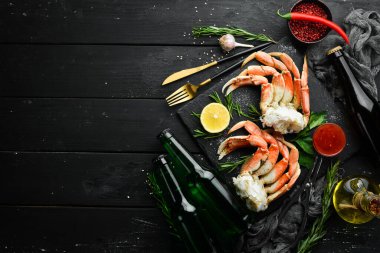 Siyah arka planda bira ve yengeç pençeleri. Kırsal tarzda. Deniz ürünleri lezzetleri..