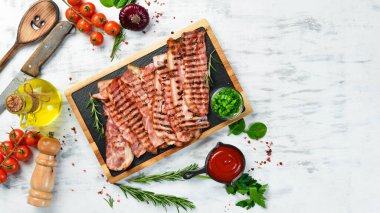 Siyah bir taş tahtada kızarmış pastırma parçaları. Üst Manzara. Metin için boş alan.