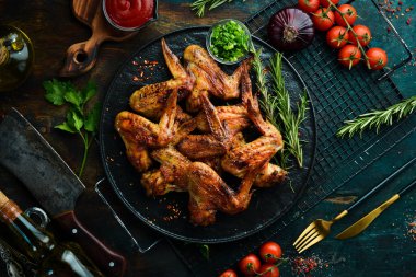 Siyah taş tabakta soslu ve baharatlı ızgara tavuk kanadı. Üst Manzara. Metin için boş alan.