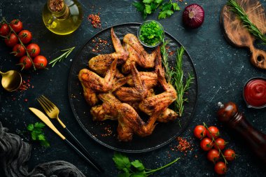 Siyah taş tabakta soslu ve baharatlı ızgara tavuk kanadı. Üst Manzara. Metin için boş alan.