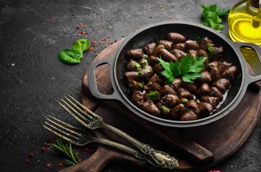 Maydanozlu kızarmış tavuk kalbi ve metal bir tavada baharat. Üst Manzara. Metin için boş alan.