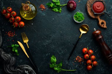 Siyah bir arka planda sebzeler, baharatlar ve otlar. Mutfak arka planı. Üst Manzara. Metin için boş alan.