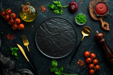 Siyah bir arka planda sebzeler, baharatlar ve otlar. Mutfak arka planı. Üst Manzara. Metin için boş alan.