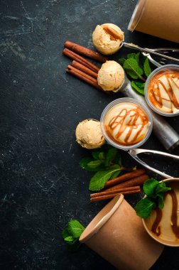 Naneli ve tuzlu karamelli karamelli dondurma. Dondurma kaşığı. Siyah taştan bir arkaplanda, üst görünüm.