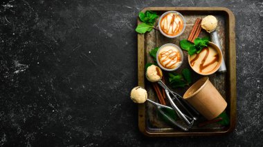 Naneli ve tuzlu karamelli karamelli dondurma. Dondurma kaşığı. Siyah taştan bir arkaplanda, üst görünüm.