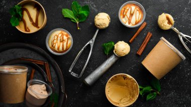 Naneli ve tuzlu karamelli karamelli dondurma. Dondurma kaşığı. Siyah taştan bir arkaplanda, üst görünüm.