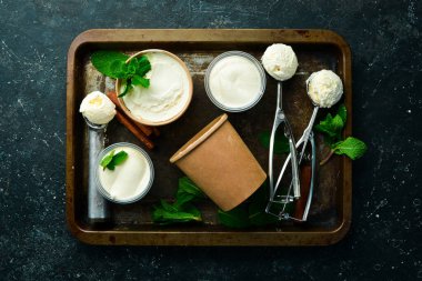 Naneli vanilyalı dondurma. Dondurma kaşığı. Siyah taştan bir arkaplanda, üst görünüm.