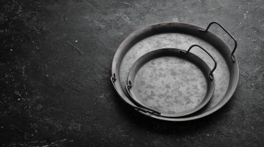 Klasik metal tepsi. Siyah taştan bir arkaplanda, üst görünüm.