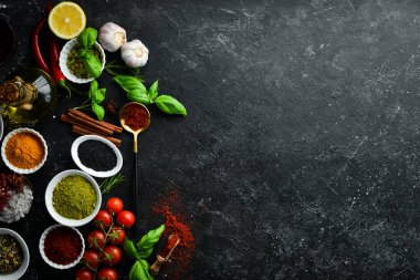 Siyah taşlı arka planda renkli baharatlar ve otlar. Yukarıdan bak. Üst görünüm.