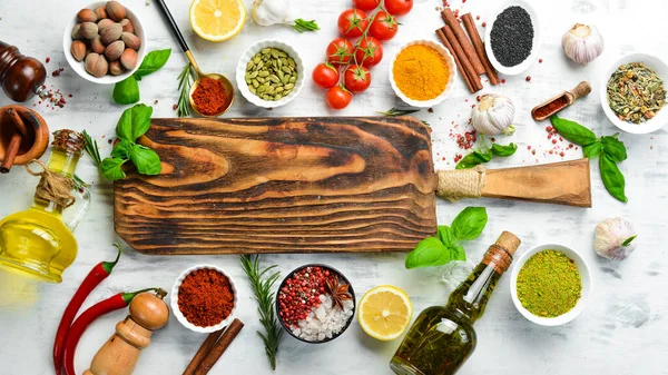 Beyaz ahşap arka planda Hint baharatları, fesleğen ve otlar. Üst Manzara. Metin için boş alan.