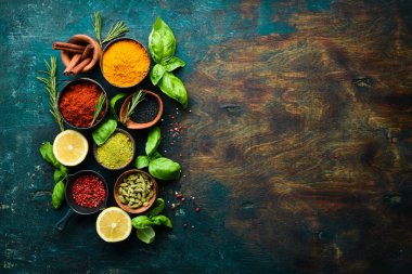 Kokulu baharatlar, otlar ve fesleğenler koyu ahşap bir arka planda. Üst Manzara. Metin için boş alan.