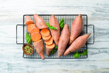 Beyaz ahşap arka planda tatlı patatesler. Beslenme yemeği. Üst Manzara. Metnin için boş yer.