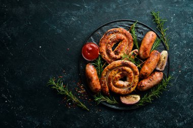 Biberiyeli ve soslu barbekü sosu. Üst Manzara. Siyah taştan bir arka planda.