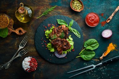 Siyah taş tabakta baharatlı kızarmış domuz bifteği. Üst Manzara. Boş kopyalama alanı.