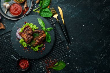 Siyah taş tabakta baharatlı kızarmış domuz bifteği. Üst Manzara. Boş kopyalama alanı.