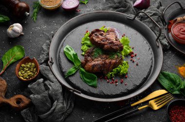 Siyah taş tabakta baharatlı kızarmış domuz bifteği. Üst Manzara. Boş kopyalama alanı.