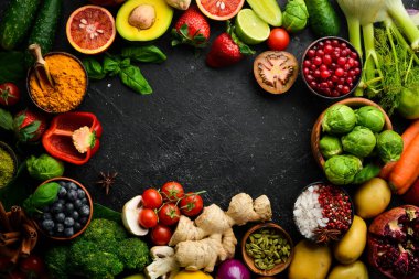 Taze sebze ve meyve: rezene, avokado, nar, böğürtlen, lahana ve fesleğen. Organik sağlıklı vejetaryen yemekleri. Siyah taştan bir arka planda.