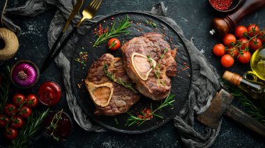 Osso buco baharat ve biberiyeyle dana inciği pişirdi. Barbekü eti. Üst Manzara. Siyah taş kesme masasının üstünde düz bir görünüm vardı..