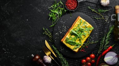 Belçika waffle 'ı: peynirli ve roka aromalı. Kahvaltıda. Siyah taştan bir tabakta.