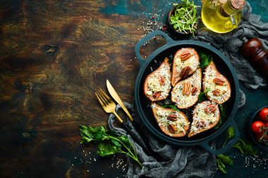 Fırında armut, mavi peynir ve fındık. Kızartma tavasında. Kırsal tarzda. Düz Yat.